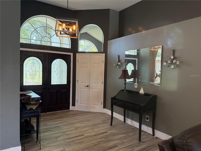 4749 Stoneview Cir, Oldsmar, FL 34677 - foyer entrance featuring a chandelier, wood finished floors, high vaulted ceiling, and baseboards