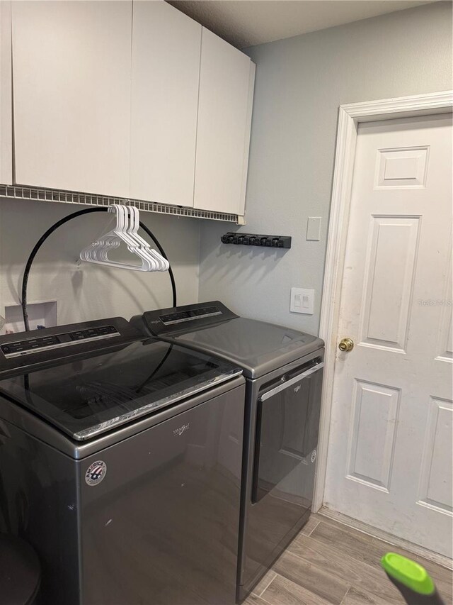 4749 Stoneview Cir, Oldsmar, FL 34677 - laundry area featuring cabinet space, washing machine and dryer, and light wood-style floors