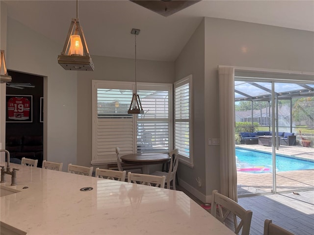 4749 Stoneview Cir, Oldsmar, FL 34677 - dining area featuring plenty of natural light, lofted ceiling, baseboards, and a sunroom