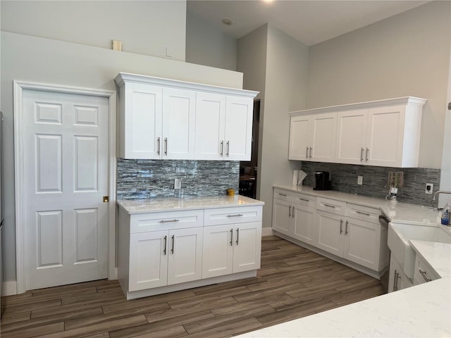 4749 Stoneview Cir, Oldsmar, FL 34677 - kitchen with backsplash, white cabinets, wood finished floors, a sink, and a high ceiling