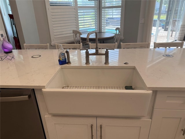 4749 Stoneview Cir, Oldsmar, FL 34677 - kitchen view of dishwasher, white cabinetry, a sink, and light stone countertops