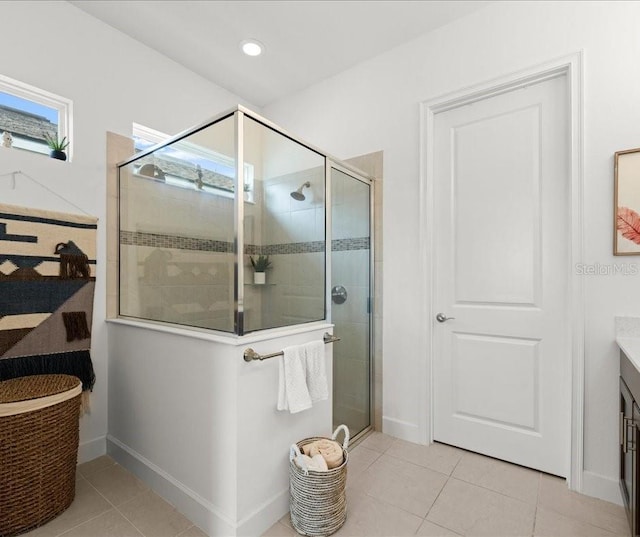 bathroom with baseboards, a shower stall, tile patterned flooring, and vanity