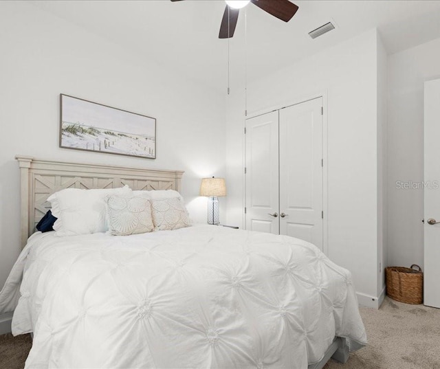 carpeted bedroom with visible vents, a closet, and ceiling fan