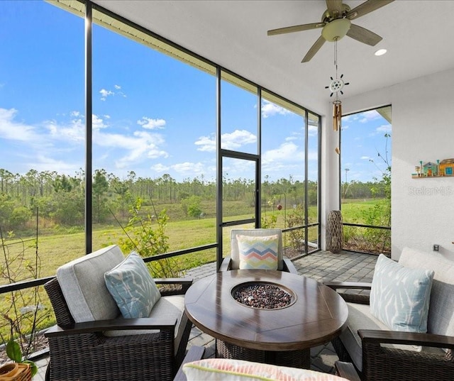 sunroom / solarium featuring an outdoor living space with a fire pit and ceiling fan