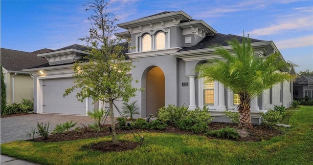 view of front of house featuring an attached garage, driveway, and stucco siding