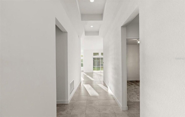 corridor featuring recessed lighting, visible vents, baseboards, and light tile patterned floors