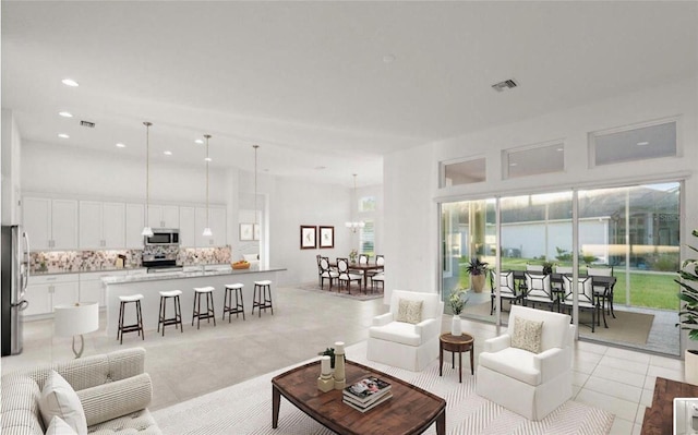 living room featuring a towering ceiling, visible vents, and recessed lighting