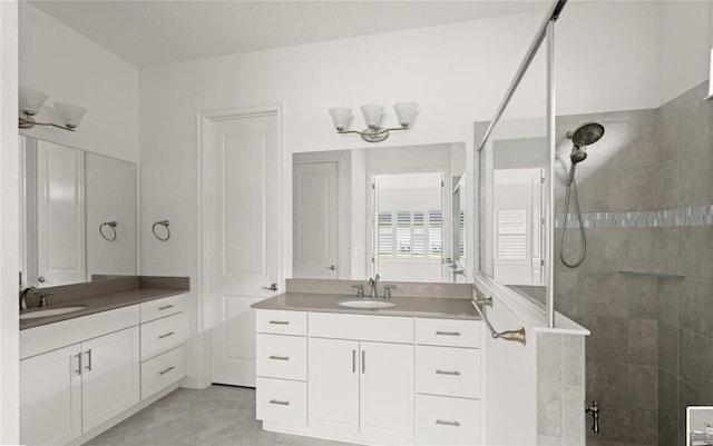 full bath with two vanities, walk in shower, and a sink