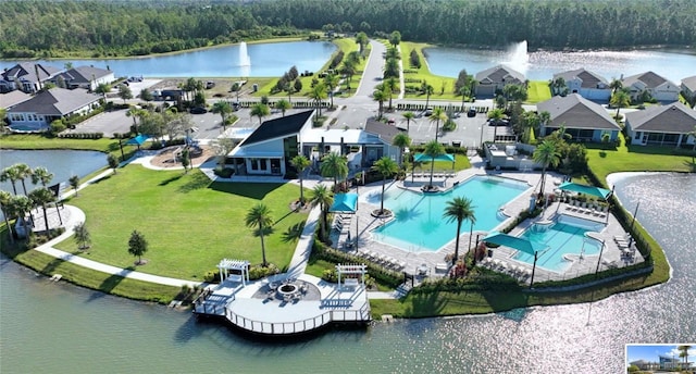 birds eye view of property with a view of trees and a water view
