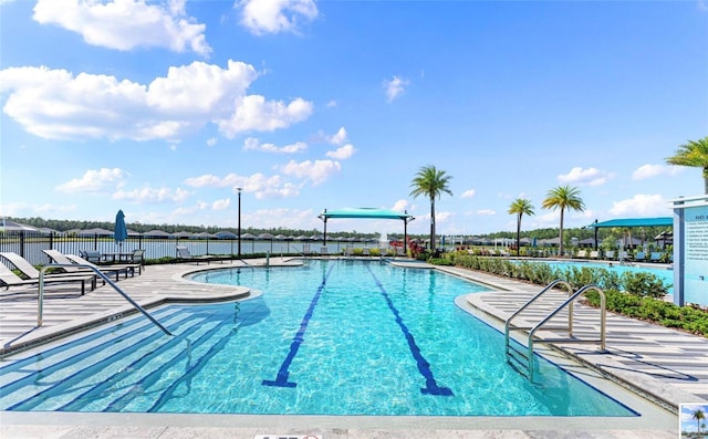 community pool with fence and a patio