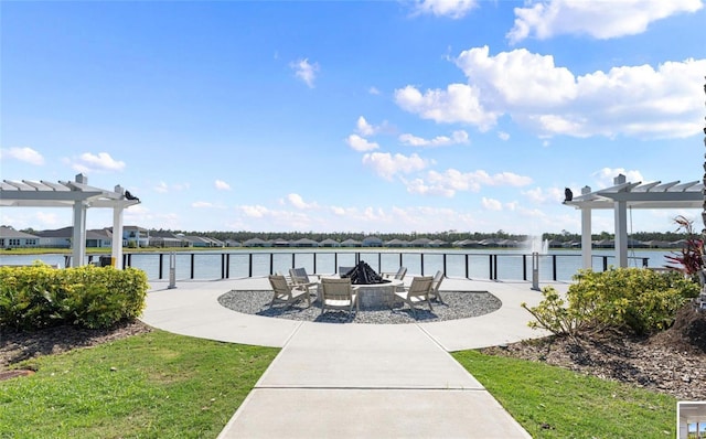 view of community with a pergola, a fire pit, and a water view