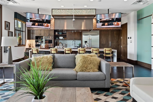 living room featuring baseboards, visible vents, and recessed lighting