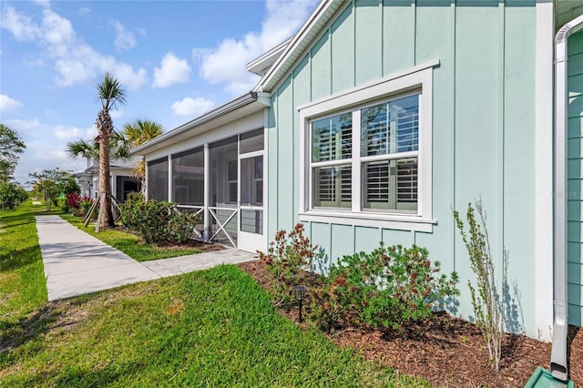 484 Landshark Blvd, Daytona Beach, FL 32124 - view of side of property featuring a lawn, board and batten siding, and a sunroom