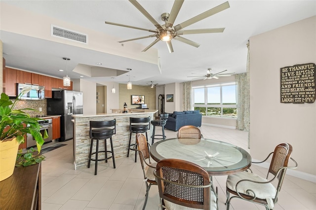 241 Riverside Dr Unit 902, Holly Hill, FL 32117 - dining room featuring a raised ceiling, visible vents, a ceiling fan, light tile patterned flooring, and baseboards