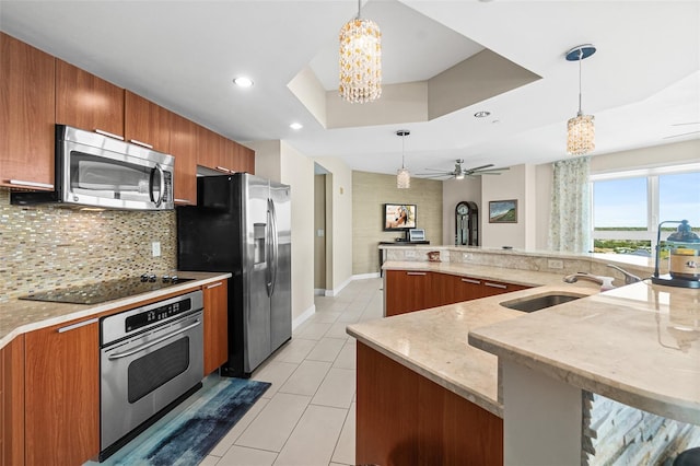241 Riverside Dr Unit 902, Holly Hill, FL 32117 - kitchen with brown cabinets, decorative backsplash, appliances with stainless steel finishes, and a sink