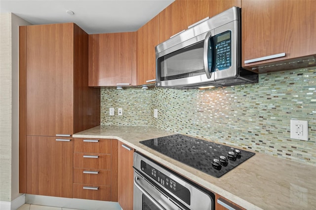 241 Riverside Dr Unit 902, Holly Hill, FL 32117 - kitchen with modern cabinets, brown cabinets, decorative backsplash, and appliances with stainless steel finishes
