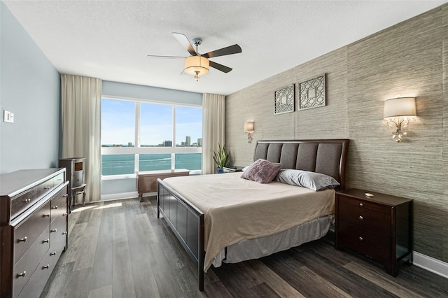 241 Riverside Dr Unit 902, Holly Hill, FL 32117 - bedroom with a textured ceiling, baseboards, a ceiling fan, dark wood-type flooring, and a view of city
