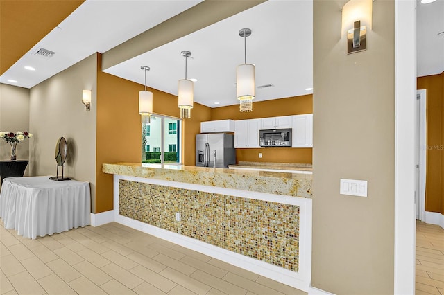 241 Riverside Dr Unit 902, Holly Hill, FL 32117 - kitchen with white cabinets, a peninsula, visible vents, stainless steel fridge with ice dispenser, and black microwave
