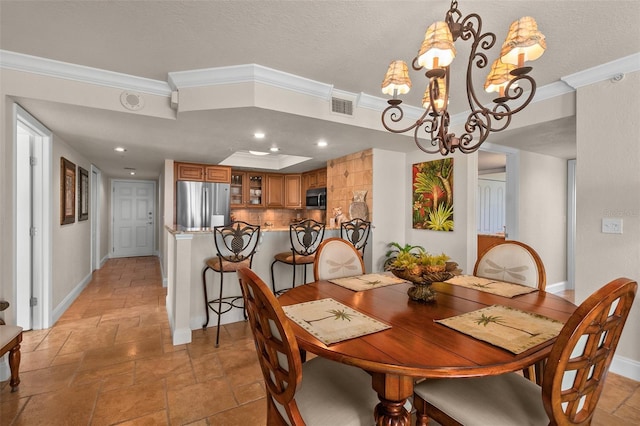 dining area with stone tile floors, crown molding, visible vents, baseboards, and a notable chandelier