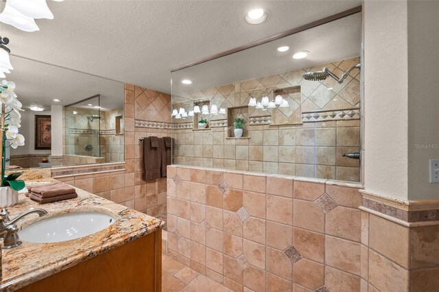 bathroom with a textured ceiling, walk in shower, recessed lighting, and tile walls