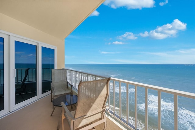 balcony featuring a view of the beach and a water view