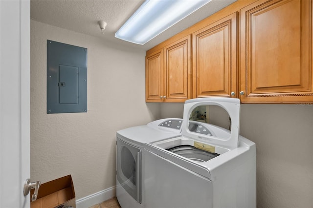 laundry area featuring a textured ceiling, independent washer and dryer, electric panel, baseboards, and cabinet space