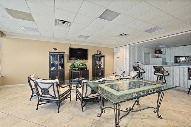 dining area featuring baseboards, visible vents, light tile patterned floors, and ornamental molding