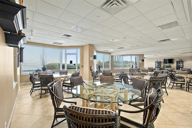 dining room featuring light tile patterned floors, visible vents, a drop ceiling, and baseboards