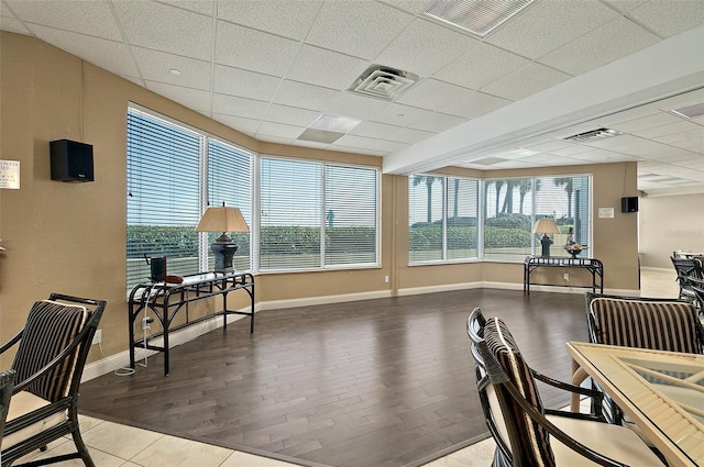 interior space with visible vents, a drop ceiling, wood finished floors, and baseboards