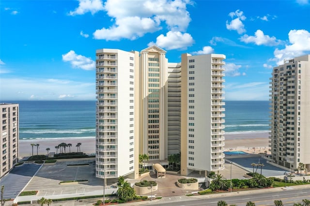 view of property with a view of the beach and a water view