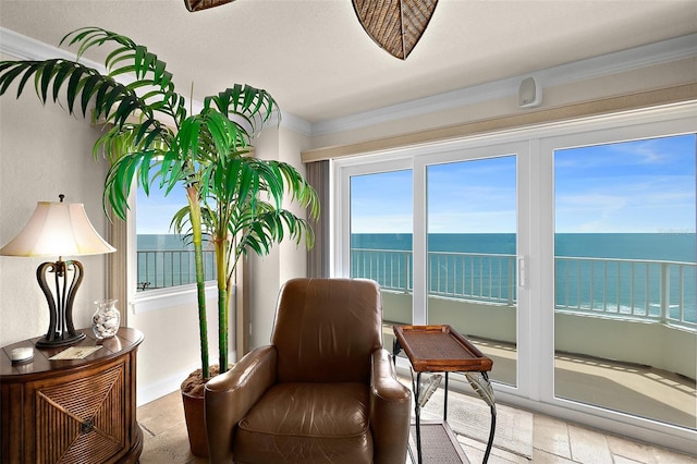 living area featuring baseboards, a water view, and crown molding
