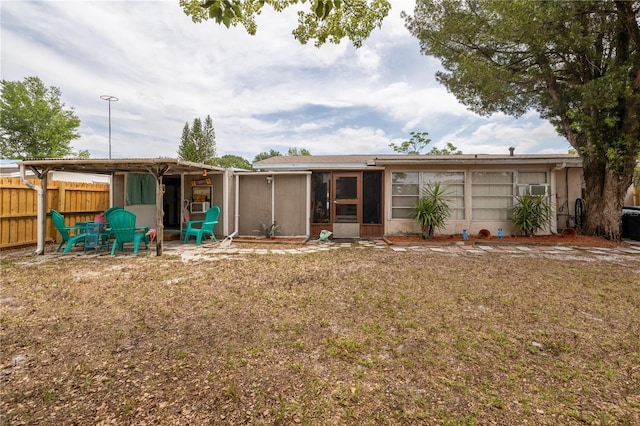 1148 Briarwood Ave, Deltona, FL 32725 - rear view of property featuring fence, a lawn, and a sunroom