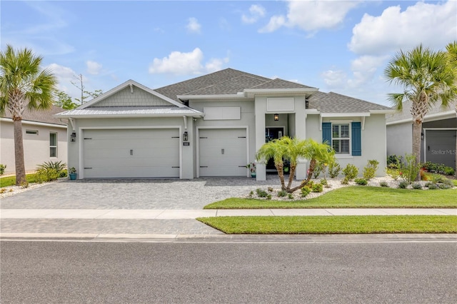 660 Mosaic Blvd, Daytona Beach, FL 32124 - view of front of property featuring an attached garage, decorative driveway, stucco siding, and roof with shingles