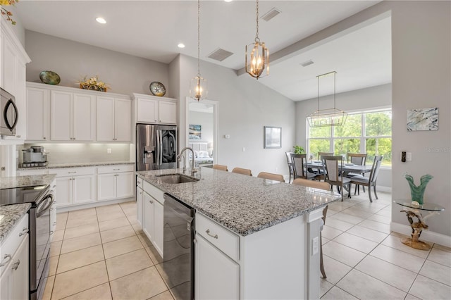 660 Mosaic Blvd, Daytona Beach, FL 32124 - kitchen with a sink, appliances with stainless steel finishes, lofted ceiling, light tile patterned floors, and a breakfast bar