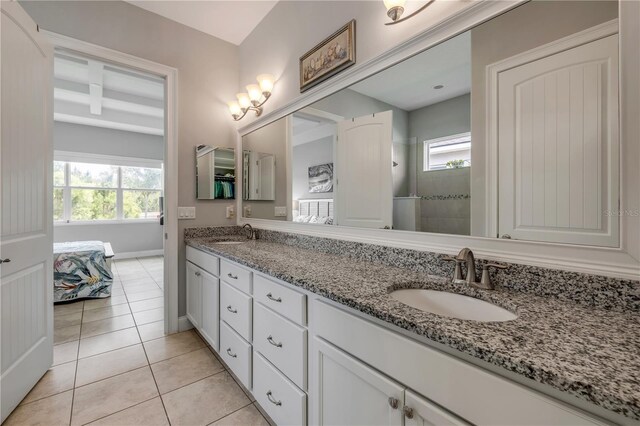 660 Mosaic Blvd, Daytona Beach, FL 32124 - bathroom with tile patterned flooring, double vanity, a tile shower, baseboards, and ensuite bath