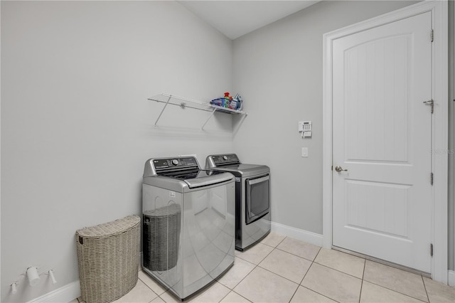 660 Mosaic Blvd, Daytona Beach, FL 32124 - washroom with washer and dryer, baseboards, and light tile patterned flooring