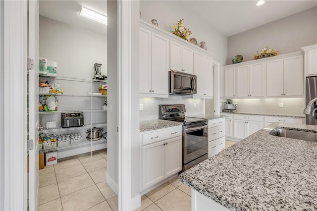 660 Mosaic Blvd, Daytona Beach, FL 32124 - kitchen featuring stainless steel appliances, a sink, tasteful backsplash, and white cabinetry