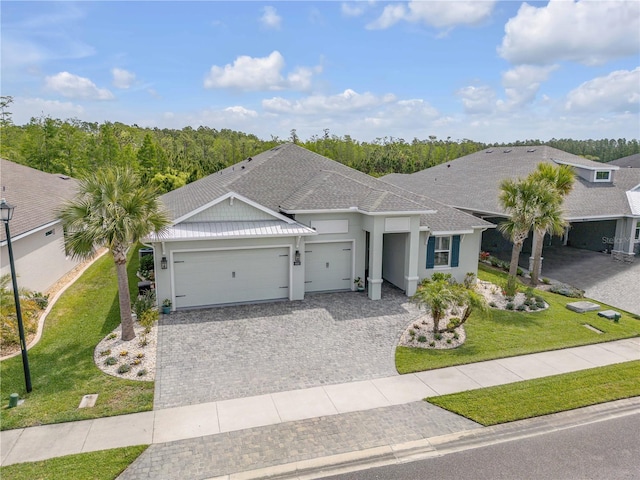 660 Mosaic Blvd, Daytona Beach, FL 32124 - single story home featuring a garage, a front lawn, decorative driveway, and stucco siding