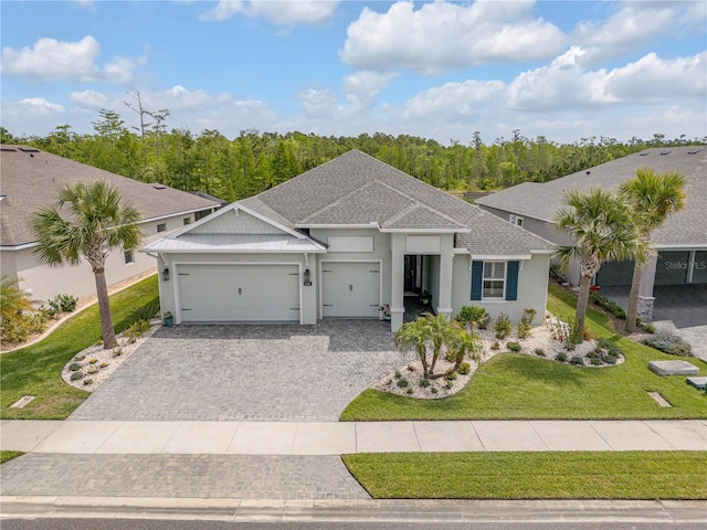 660 Mosaic Blvd, Daytona Beach, FL 32124 - single story home with an attached garage, stucco siding, a shingled roof, a front lawn, and decorative driveway