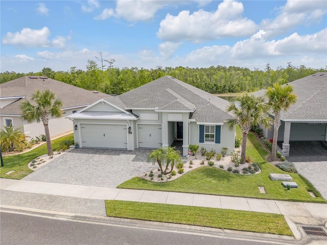 660 Mosaic Blvd, Daytona Beach, FL 32124 - single story home with an attached garage, stucco siding, a front lawn, decorative driveway, and a shingled roof