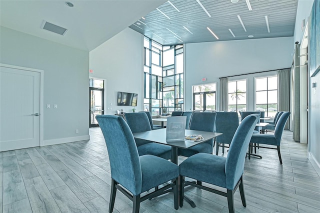 660 Mosaic Blvd, Daytona Beach, FL 32124 - dining room featuring a high ceiling, plenty of natural light, light wood-style flooring, and baseboards