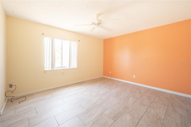 spare room featuring baseboards and ceiling fan