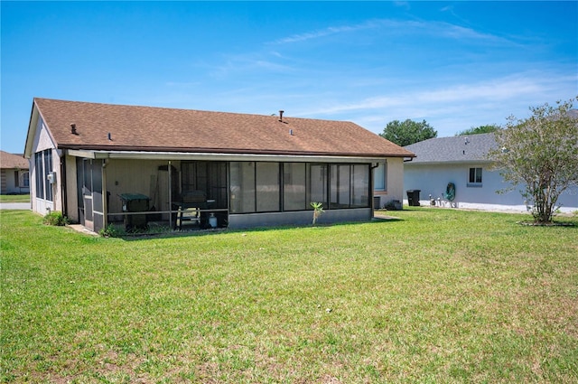 rear view of house with a lawn and a sunroom