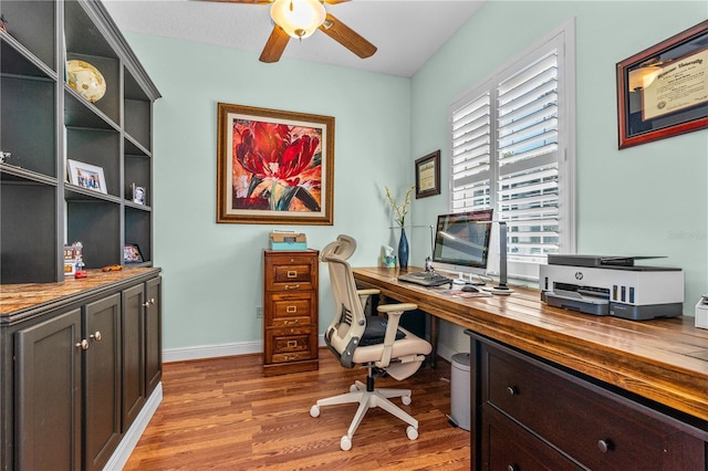 office with baseboards, a ceiling fan, and light wood-type flooring
