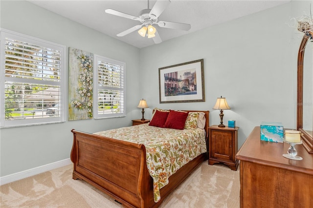 bedroom with light carpet, a ceiling fan, and baseboards