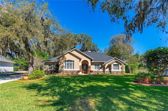 ranch-style home featuring stone siding, a front lawn, and stucco siding