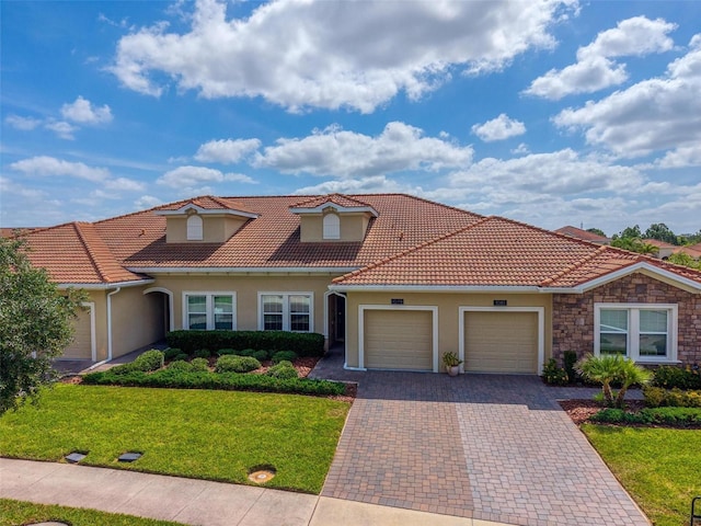 1079 Quaker Ridge Ln, Davenport, FL 33896 - mediterranean / spanish-style home featuring a front yard, stucco siding, decorative driveway, a tiled roof, and an attached garage
