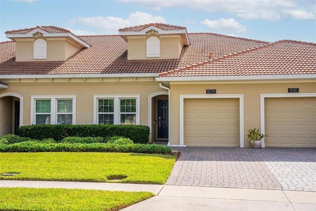 1079 Quaker Ridge Ln, Davenport, FL 33896 - mediterranean / spanish house with stucco siding, decorative driveway, a garage, a tile roof, and a front yard