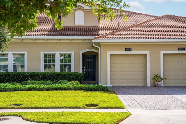 1079 Quaker Ridge Ln, Davenport, FL 33896 - view of front of property featuring stucco siding, decorative driveway, and a tiled roof