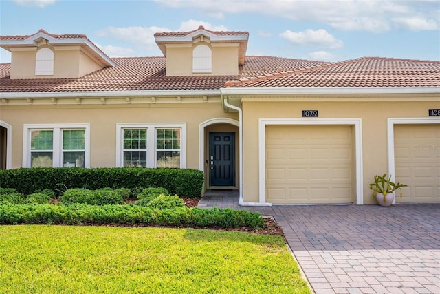 1079 Quaker Ridge Ln, Davenport, FL 33896 - mediterranean / spanish-style home featuring a tile roof, a front yard, driveway, and stucco siding